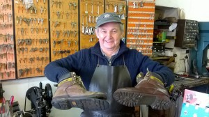 Steve Knight, Cobbler holding boots, comparing repaired and broken, background rows of uncut keys